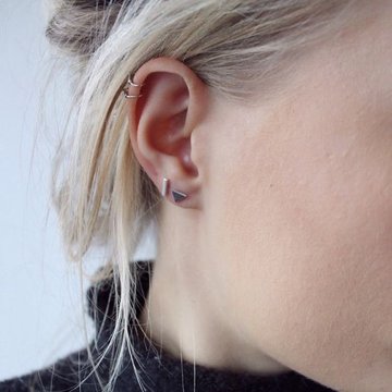 Woman showing healed double helix piercing