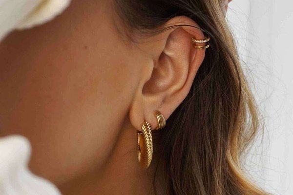 Woman showing healed double helix piercing