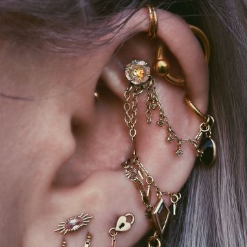 Double vertical helix piercing with gold hoops