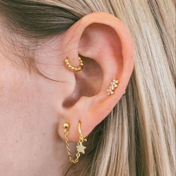 Woman with forward helix piercing and gold hoop