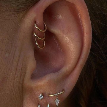 Triple forward helix piercing with small gold hoops