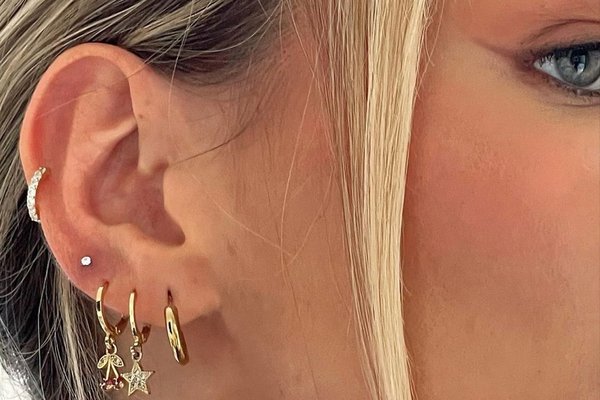 Close-up of mid helix piercing with gold hoop