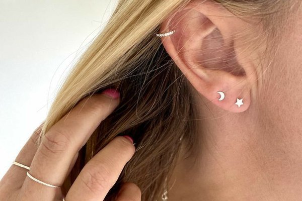 Close-up of mid helix piercing with gold hoop