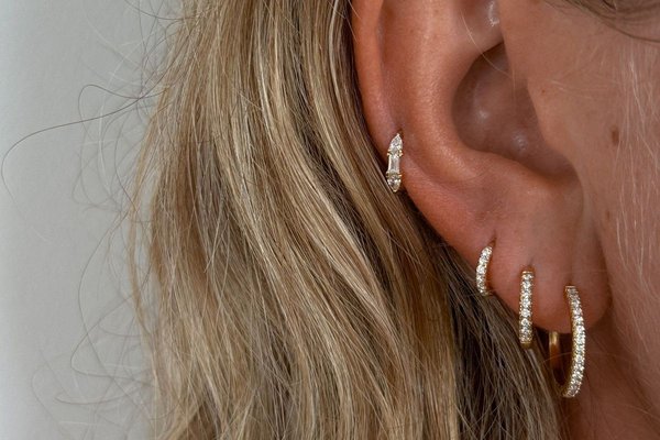 Close-up of mid helix piercing with gold hoop