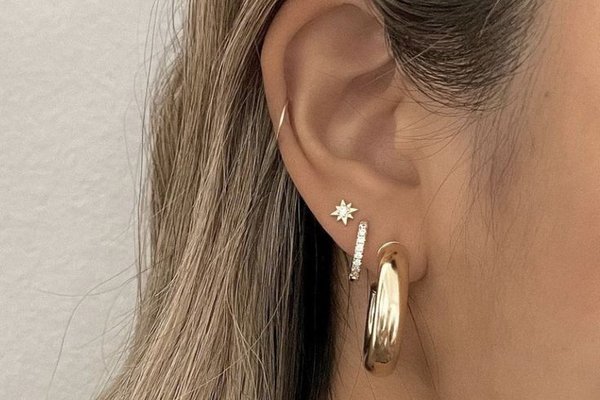Close-up of mid helix piercing with gold hoop
