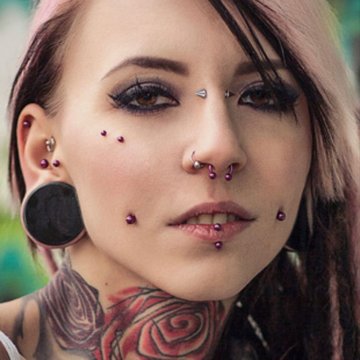 Artistic close-up of cheek dermal piercing with opal gem