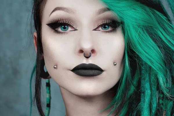 Close-up of a cheek dermal piercing with a small gemstone stud