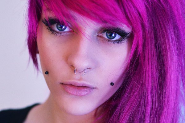 Artistic close-up of cheek dermal piercing with opal gem