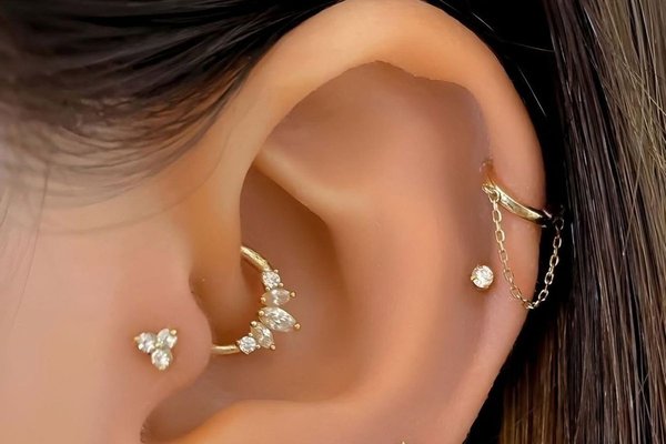 Double helix ear piercing close-up with stud jewelry
