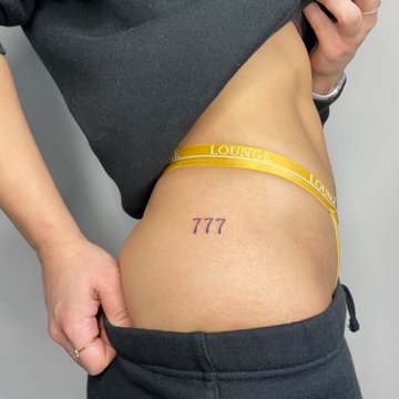 Tattoo 777 on the thigh
