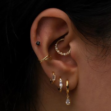Stylish female ear with conch and mid helix in silver hoops