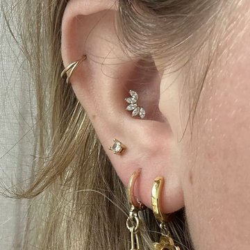 Conch piercing stud paired with mid helix gold hoop