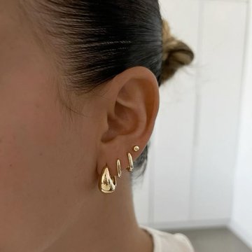 Low helix piercing combined with lobe earrings