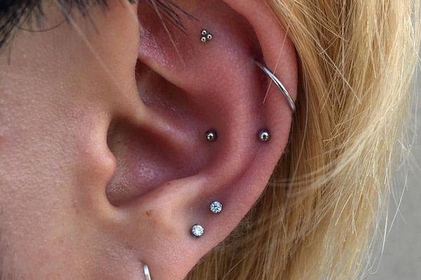 Double low helix piercing with two studs